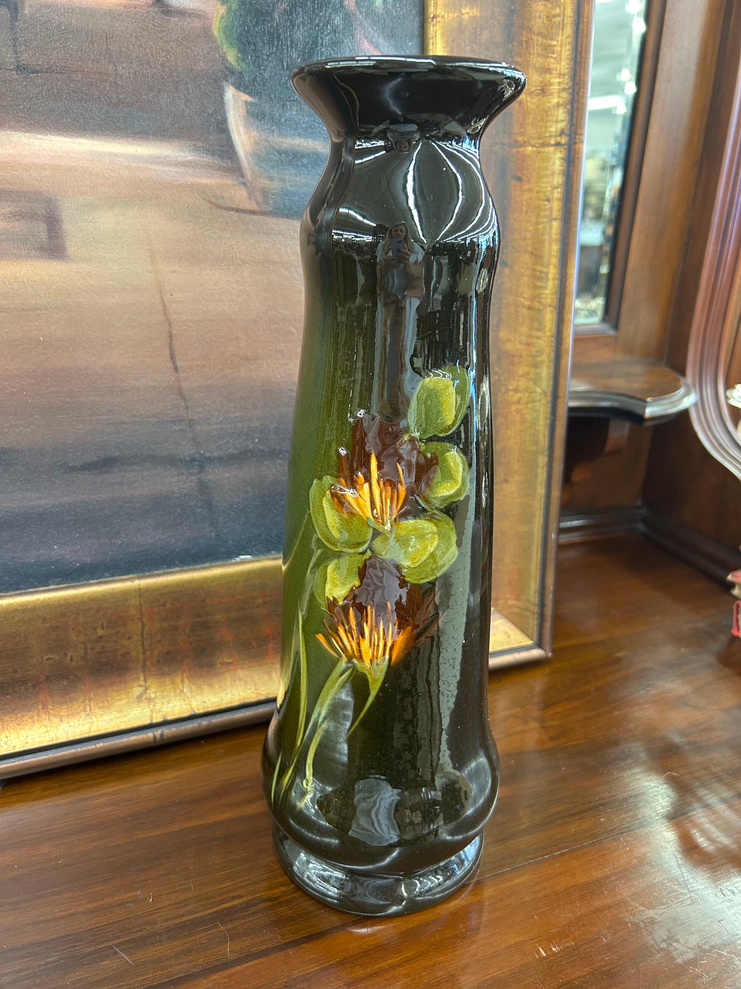 Art pottery vase with a rich dark glaze and raised floral detail (small chip at base)